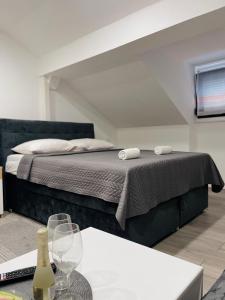 1 dormitorio con 1 cama y 1 mesa con copas de vino en Sobe Darko Cindrić, en Karlovac