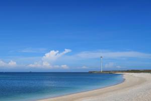 een strand met een windmolen in het midden van de oceaan bij SUNME Inn in Magong