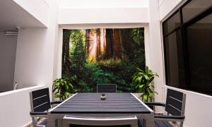 a dining room with a table and a forest mural at Hotel Arisha Cali in Cali