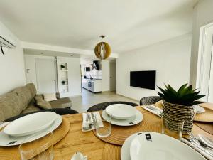 een eetkamer met een tafel met witte borden erop bij MALTA LUXE in Salou