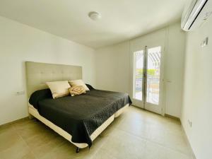 een slaapkamer met een bed en een groot raam bij MALTA LUXE in Salou