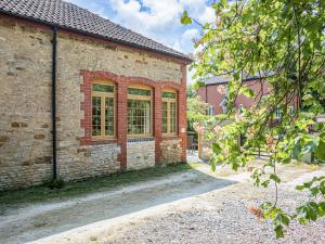 un edificio de ladrillo con ventanas laterales en The Old Stable en Dursley