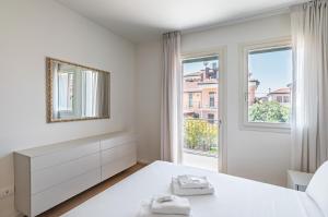 - une chambre blanche avec un lit et une fenêtre dans l'établissement Padova Cozy&Chic Aparment, à Padoue