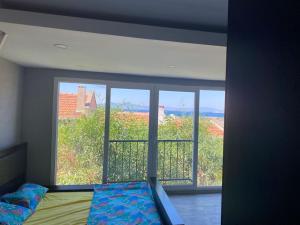 a bedroom with a bed and a large window at Yeni Foça’da teraslı müstakil ev in Yenifoça