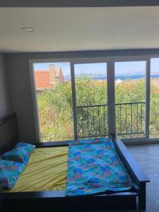 1 dormitorio con cama y ventana con vistas en Yeni Foça’da teraslı müstakil ev en Yenifoca