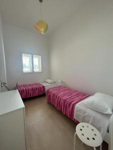 a bedroom with two beds and a table and a chair at SALENTO AT HOME in Nardò