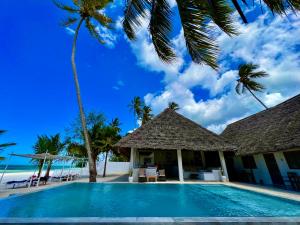 a villa with a swimming pool on the beach at White Dream Lodge & Restaurant, Beach Front, Ocean View in Kiwengwa