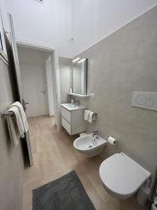 a bathroom with a white toilet and a sink at SALENTO AT HOME in Nardò