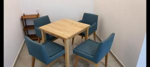 una mesa con cuatro sillas azules alrededor en Kid Slide Family Apartment with 2 Bedroom + 2 Bath, en Masai