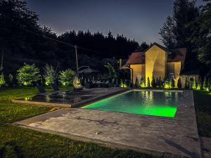 una casa con piscina por la noche en Tronoska Oaza Korenita, Loznica en Loznica
