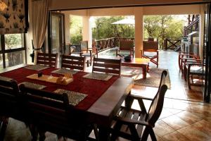 a dining room with a wooden table and chairs at Eden Safari Country House in Marloth Park
