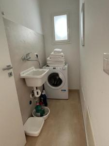 a bathroom with a washing machine and a sink at SALENTO AT HOME in Nardò