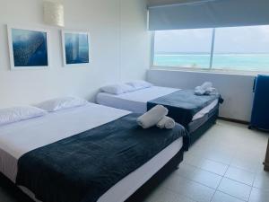 twee bedden in een kamer met uitzicht op de oceaan bij San Andrés espectacular apto frente al mar, WI-FI in San Andrés