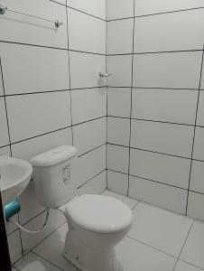 biała łazienka z toaletą i umywalką w obiekcie Apartamento Mobiliado no Centro da Cidade w mieście Imperatriz
