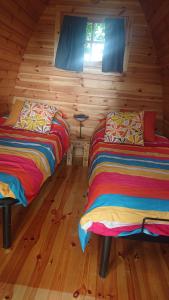 a room with two beds in a log cabin at Le Cocoon Asniérois in Asnières-sur-Vègre