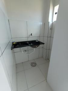 uma pequena casa de banho branca com um lavatório e um espelho. em Apartamento Mobiliado no Centro da Cidade em Imperatriz
