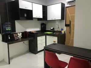 una cocina con armarios blancos y negros y sillas rojas en Studio Wifi Tv Ar-condicionado Orla Conforto, en Petrolina