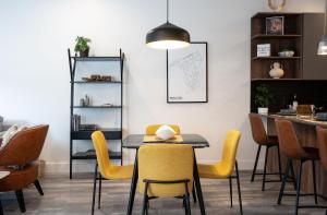 a dining room with a table and yellow chairs at Summit Place - Condo With Mountain Views in Revelstoke