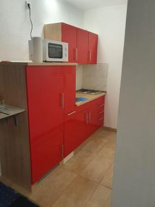 a kitchen with red cabinets and a microwave on top at ST2 Apartment in Triberg