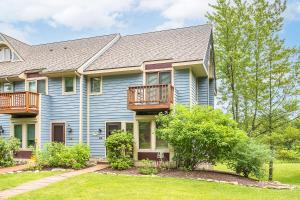 a house with blue siding and a balcony at Beary Relaxing in McHenry
