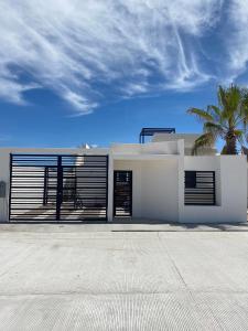 um edifício branco com uma palmeira em frente em Casa Relax w/Pool & Rooftop Lounge em El Centenario