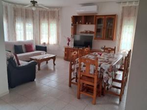 een keuken en een woonkamer met een tafel en stoelen bij CASA MARIA CINTA in Deltebre