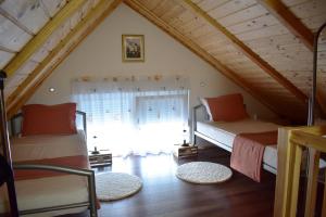 sypialnia na poddaszu z 2 łóżkami i oknem w obiekcie Apartman Tea w mieście Valpovo