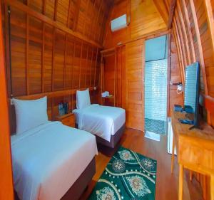 Padangnegeri的住宿－Palma Beach Resort，一间卧室配有两张床和电视。
