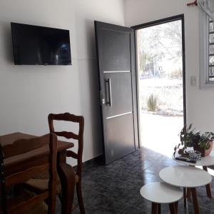 a room with a table and a door and a table and a chair at El Cañaveral in Capilla del Monte