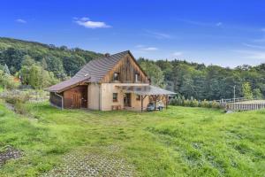 a barn in a field of grass with trees at Chalupa Sababsh Třebušín 