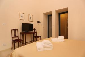 クトロフィアーノにあるVilla Lucrezio Resortのベッドルーム(ベッド1台、テレビ、タオル付)
