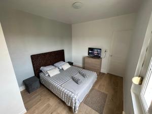 a small bedroom with a bed and a television at La clé de FA - Fibre Wifi - Parking - Calme et tranquilité in Troyes