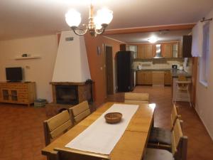 uma cozinha e sala de jantar com uma mesa e uma lareira em Chalupa Sababsh Třebušín 