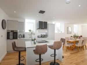 a kitchen and dining room with a table and chairs at The School House in Holyhead