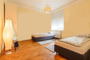 een slaapkamer met 2 bedden en een lamp erin bij Gundulic in Belgrado
