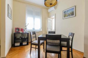a dining room with a black table and chairs at Gundulic in Belgrade