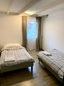 a bedroom with two beds and a window at Halek Hem - Haga loft in Enånger