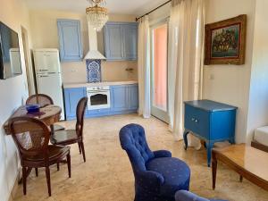 a kitchen with blue cabinets and a table and chairs at ST NIKOLA PANORAMIC SUITES HALKIDIKI in Agios Nikolaos