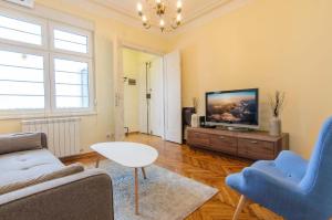 een woonkamer met een bank en een tv bij Gundulic in Belgrado