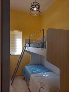 a room with two bunk beds and a light at CASA VACANZA DEL SOLE in Milo