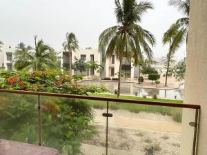 a balcony with a view of a pool and palm trees at Hawana salalah in Wādī Khasbar