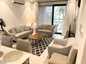 a living room with couches chairs and a table at Hawana salalah in Wādī Khasbar