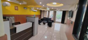 um átrio com uma sala de espera com paredes amarelas em The Grand Suite-70 em Noida