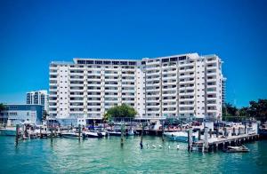 a large building with a marina and boats in the water at Deluxe waterfront one bedroom apartment with free parking 5 mins drive to Miami Beach in Miami Beach
