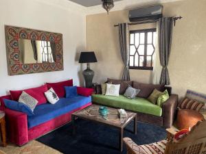 ein Wohnzimmer mit zwei farbigen Sofas und einem Tisch in der Unterkunft VILLA ALWAN BARAKA - Sans vis à vis, Piscine chauffée, Hammam, Personnel in Essaouira