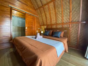 1 dormitorio con 1 cama en una habitación de madera en D'Yoga Bamboo House, en Kintamani