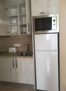a kitchen with a white refrigerator and a microwave at Independiente estudio en acogedora casita de Mai in Adeje