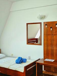 una camera da letto con un letto con uno specchio sul muro di Restoran Lovac a Novi Kneževac