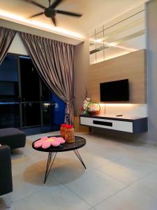 - un salon avec une télévision et une table dans l'établissement Share Room Atlantis Residences, à Malacca