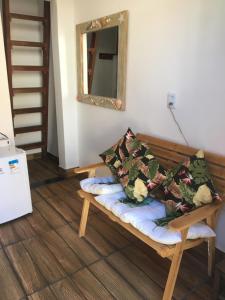 グアジルにあるBuda Guajirú - Pé na areia - Praia de Guajirúの枕付きのベンチと鏡が備わる客室です。